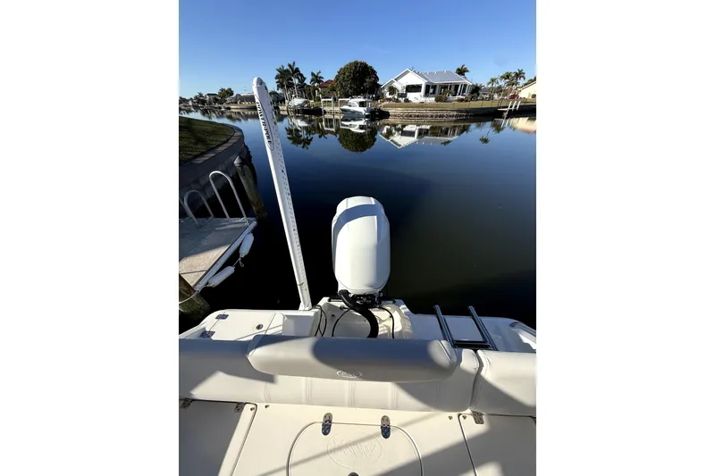 Slide: The Image of 2023 Key West 219 FS boat on calm water, residential backdrop. - 2