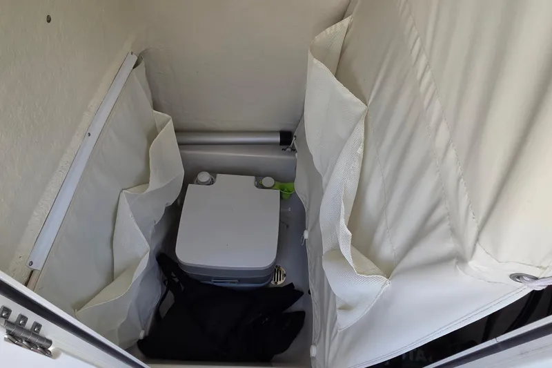 Slide: The Image of Interior of 2023 Key West 219 FS boat with portable toilet and storage pockets. - 22