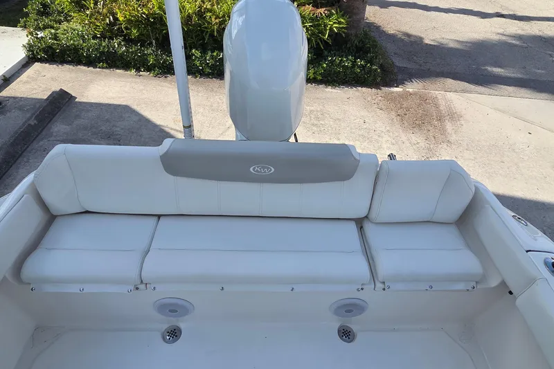 Slide: The Image of 2023 Key West 219 FS boat interior with white cushioned seating and motor. - 24