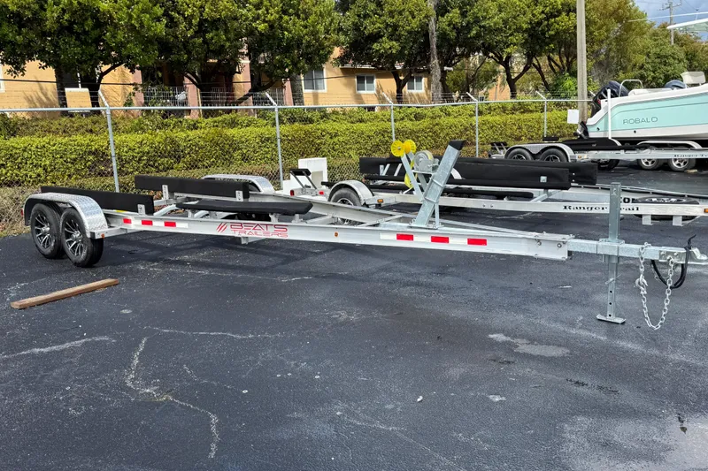 Slide: The Image of 2023 Key West 219 FS boat trailer parked on asphalt near greenery. - 8