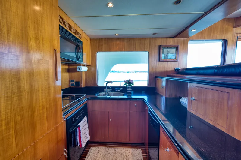 Slide: The Image of Luxurious 2003 Ocean Alexander 700 Classicco yacht kitchen with wood cabinetry and modern appliances. - 25