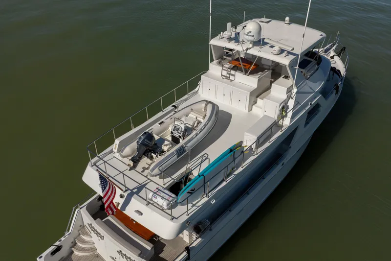 Slide: The Image of Ocean Alexander 700 Classicco 2003 yacht with deck view, featuring a small boat and American flag. - 64