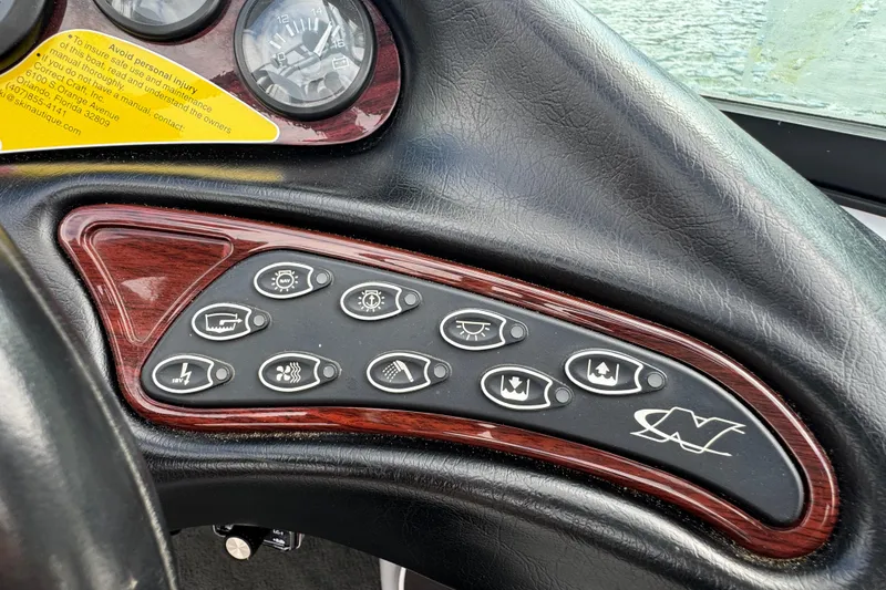 Slide: The Image of Dashboard controls of a 2000 Correct Craft Super Air Nautique boat with wood trim accents. - 13