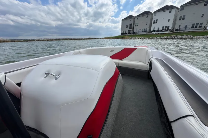 Slide: The Image of 2000 Correct Craft Super Air Nautique boat interior with red and white seating on a lake. - 23
