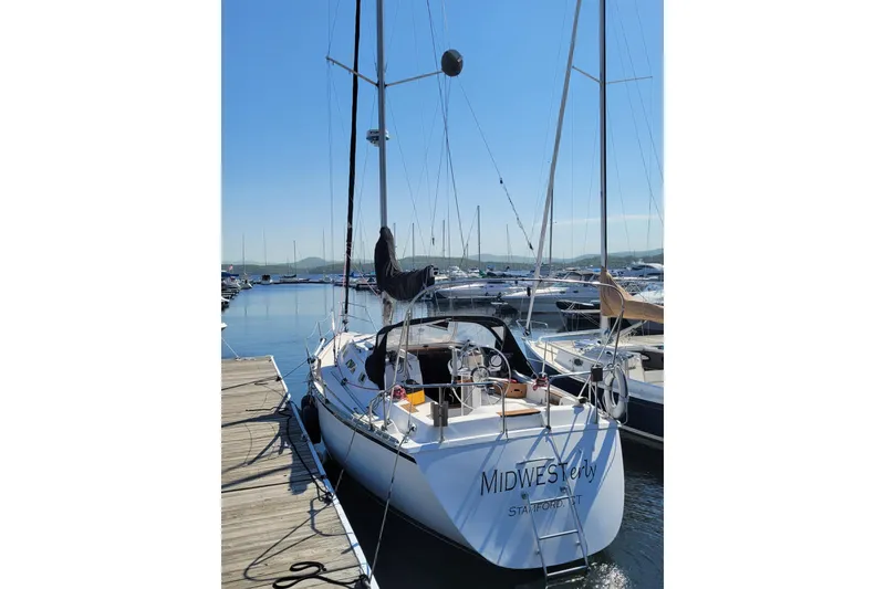 Slide: The Image of 1985 Hunter 31 sailboat docked at marina, clear sky, calm water. - 2