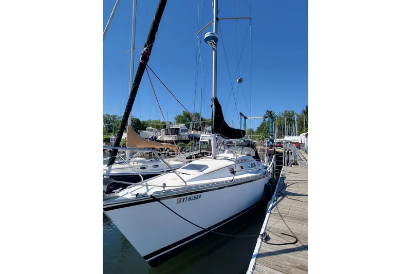 Slide: The Image of 1985 Hunter 31 sailboat docked at marina under clear blue sky. - 3