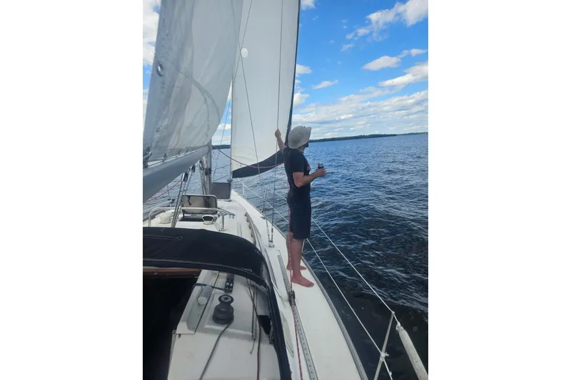 Slide: The Image of Man sailing on 1985 Hunter 31 yacht, enjoying a sunny day on the water. - 5