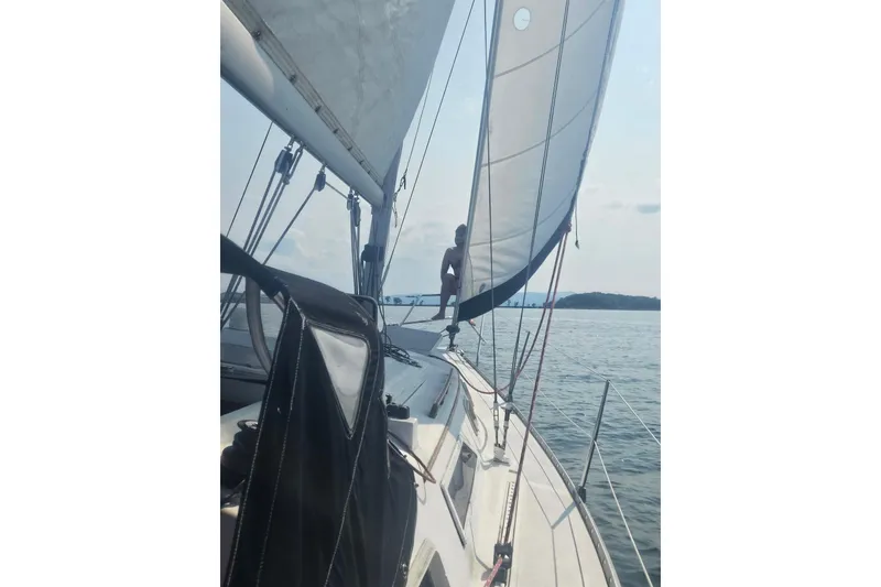 Slide: The Image of Sailing on a 1985 Hunter 31 yacht with open sails on a calm sea. - 7