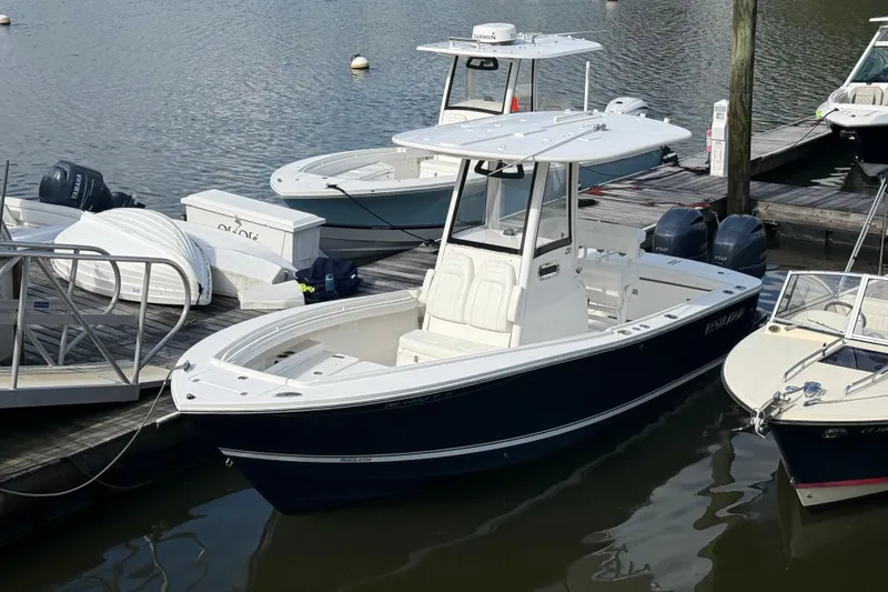 The Image of 2022 Regulator 23 boat docked at marina, featuring sleek design and twin engines. - 0