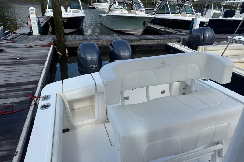 Slide: The Image of 2022 Regulator 23 boat docked, featuring dual 150 horsepower engines and white seating. - 14