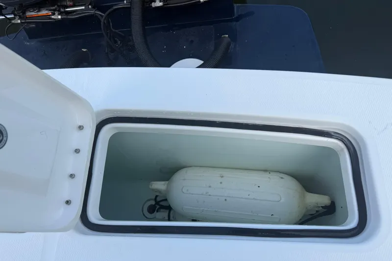 Slide: The Image of Open storage compartment on 2022 Regulator 23 boat with a white fender inside. - 15