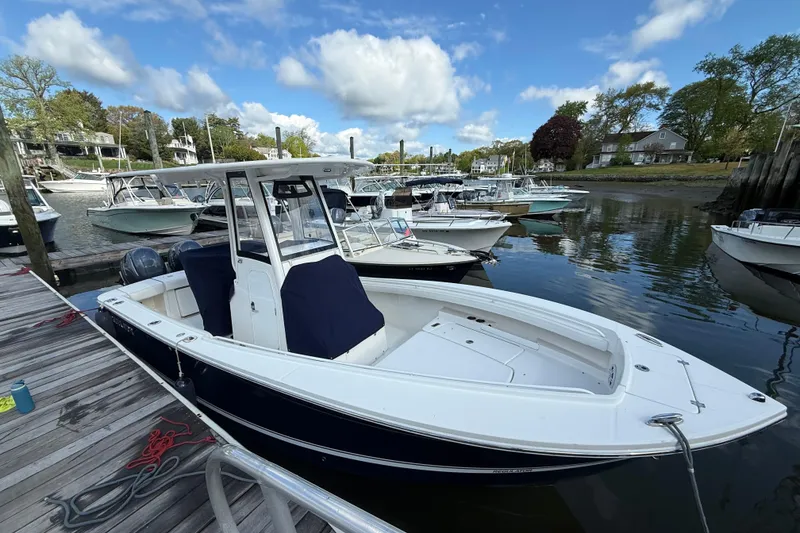 Slide: The Image of 2022 Regulator 23 boat docked in a marina under a blue sky. - 2