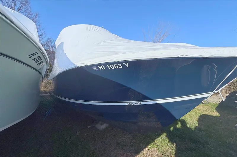 The Image of 2022 Regulator 23 boat covered and parked on grass. - 3