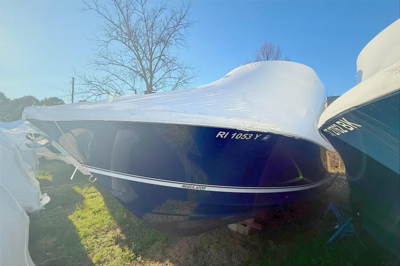 Slide: The Image of 2022 Regulator 23 boat, blue, in storage with cover. - 4