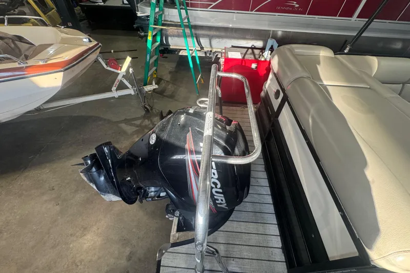 Slide: The Image of 2018 Trifecta SS 21FC pontoon boat with Mercury outboard motor in a garage setting. - 19