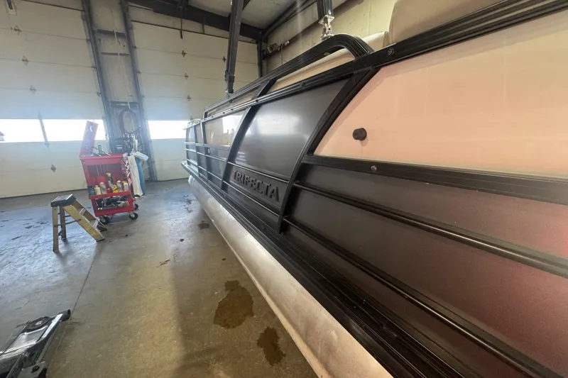 Slide: The Image of 2018 Trifecta SS 21FC pontoon boat in a garage with tools and equipment. - 4