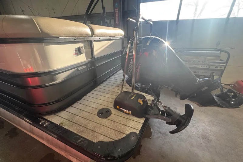 Slide: The Image of 2018 Trifecta SS 21FC pontoon boat with Minn Kota motor in a garage setting. - 5