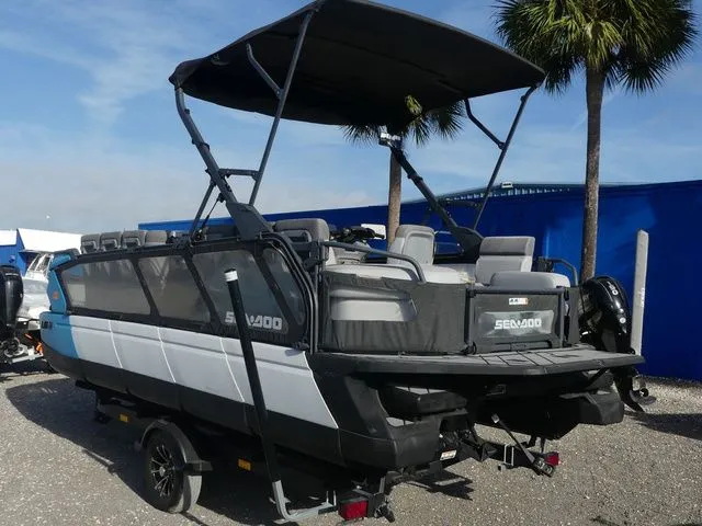 Slide: The Image of 2022 Sea-Doo Switch® Cruise 21 pontoon boat with canopy, parked under palm trees. - 6