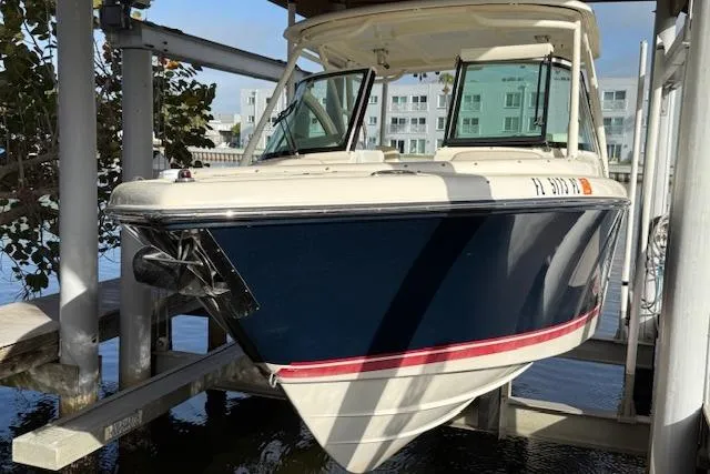 The Image of 2011 Pursuit DC 265 Dual Console boat docked, featuring sleek design and spacious seating. - 0