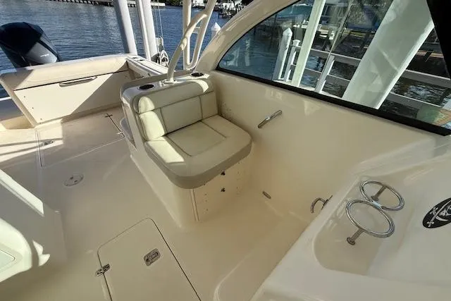 Slide: The Image of 2011 Pursuit DC 265 Dual Console boat interior with seating and cup holders. - 15