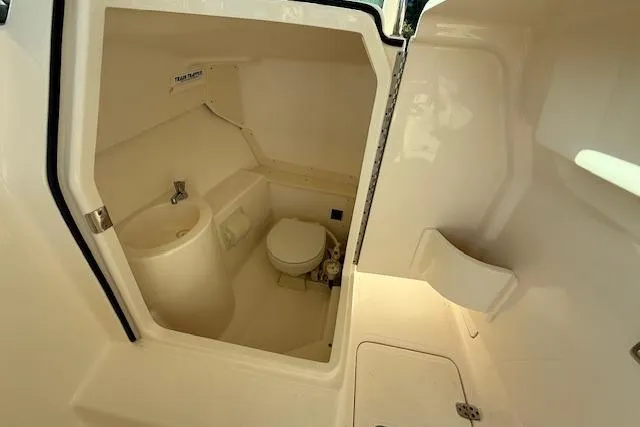 Slide: The Image of 2011 Pursuit DC 265 Dual Console boat interior with compact bathroom amenities. - 17