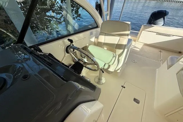 Slide: The Image of 2011 Pursuit DC 265 Dual Console boat interior with steering wheel and seating. - 18