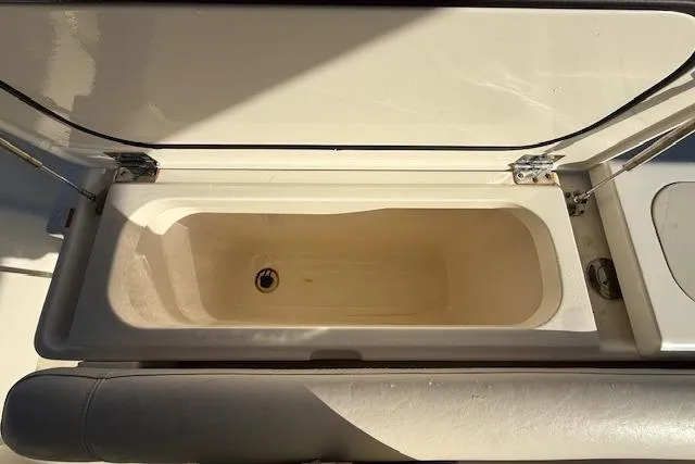Slide: The Image of Open storage compartment on a 2011 Pursuit DC 265 Dual Console boat. - 24