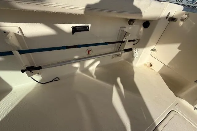 Slide: The Image of Interior of a 2011 Pursuit DC 265 Dual Console boat showing rod holders and storage area. - 25
