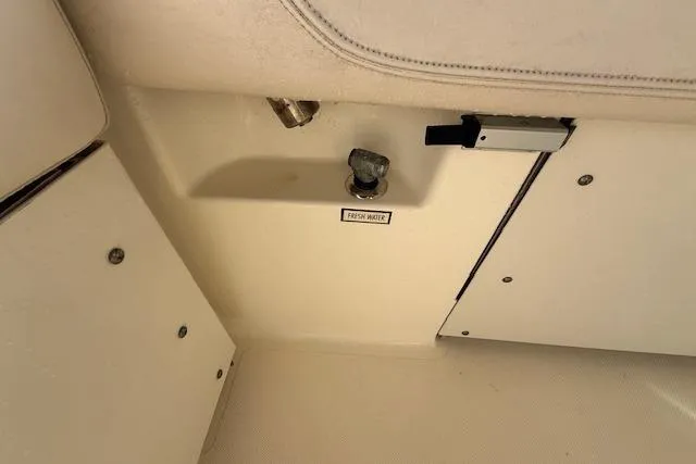 Slide: The Image of Interior view of a 2011 Pursuit DC 265 Dual Console boat, featuring storage compartments. - 26