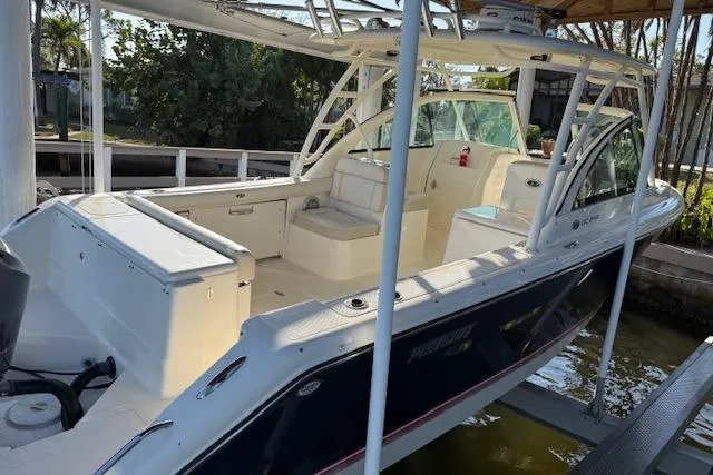 Slide: The Image of 2011 Pursuit DC 265 Dual Console boat docked, featuring spacious seating and sleek design. - 4