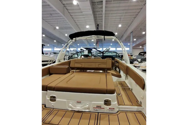 Slide: The Image of 2026 Chaparral SSX 4 boat interior with tan seating, showcased in a well-lit showroom. - 5