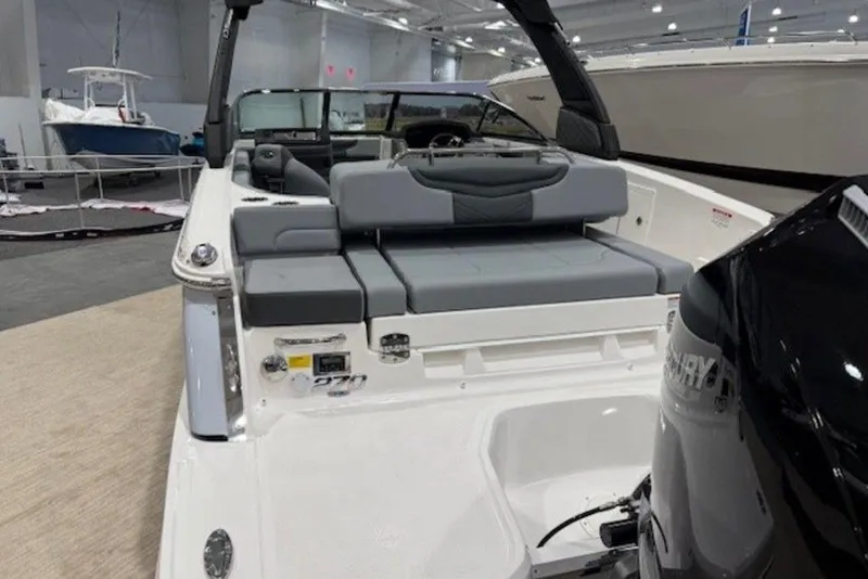Slide: The Image of 2026 Chaparral 270 OSX boat interior with seating and Mercury engine in showroom. - 5