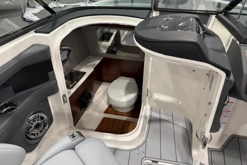 Slide: The Image of 2026 Chaparral 270 OSX boat interior with compact bathroom and modern amenities. - 8