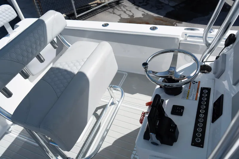 Slide: The Image of 2023 Contender 24 Sport boat cockpit with steering wheel and seating. - 10