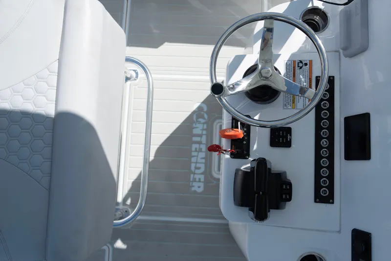 Slide: The Image of 2023 Contender 24 Sport boat console with steering wheel and controls. - 11