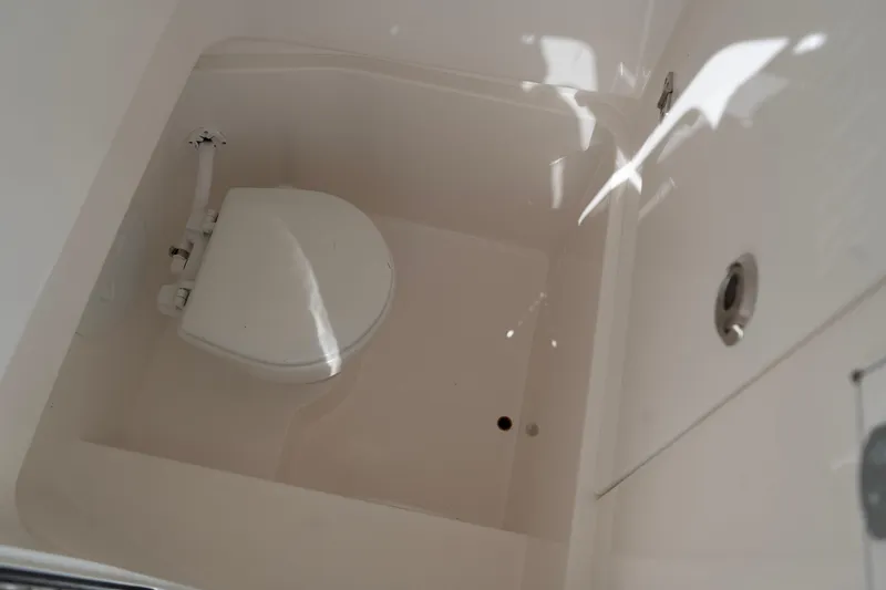 Slide: The Image of 2023 Contender 24 Sport boat interior with compact marine toilet. - 14