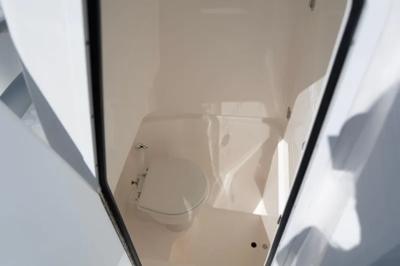 Slide: The Image of 2023 Contender 24 Sport boat interior with compact marine toilet. - 15