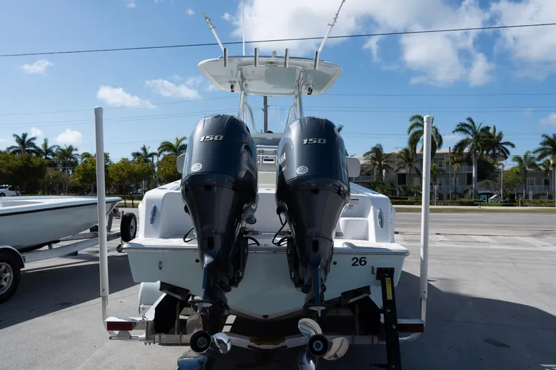 Slide: The Image of 2023 Contender 24 Sport boat with dual 150 horsepower engines, parked outdoors. - 17