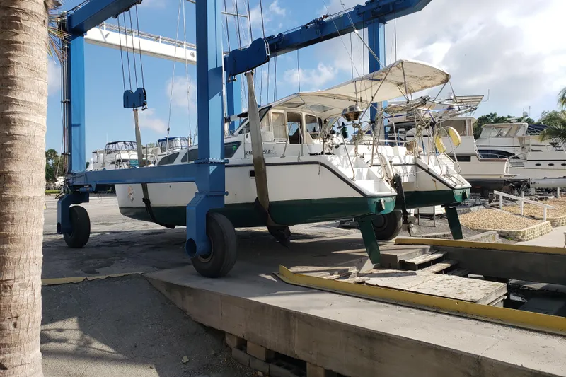 Slide: The Image of 2006 Gemini 105 MC catamaran on a boat lift at a marina. - 18