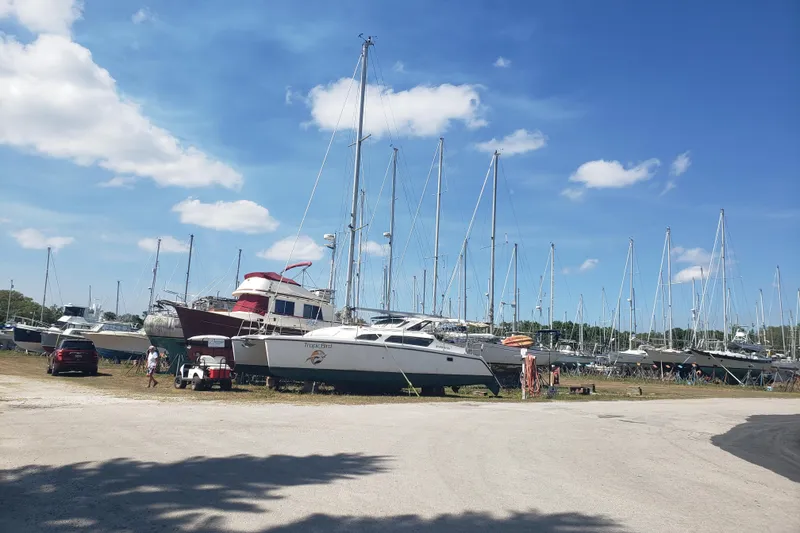 Slide: The Image of Boats in a marina, featuring a 2006 Gemini 105 MC under a clear blue sky. - 19
