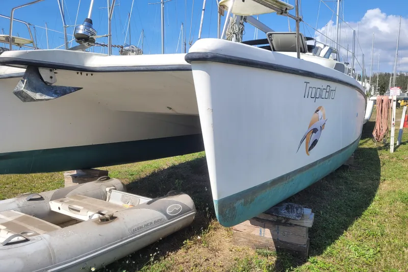 Slide: The Image of 2006 Gemini 105 MC catamaran "TropicBird" on land with inflatable boat nearby. - 21