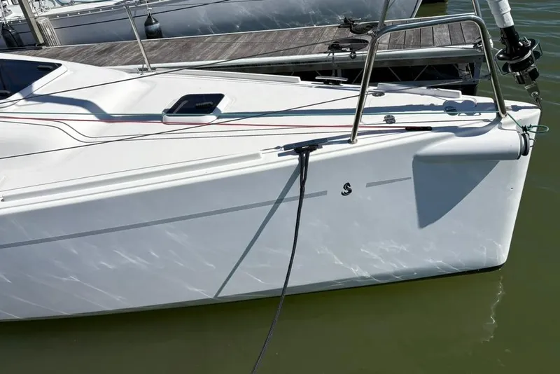 Slide: The Image of 2024 Beneteau First 27 sailboat docked, showcasing sleek white hull and modern design. - 2