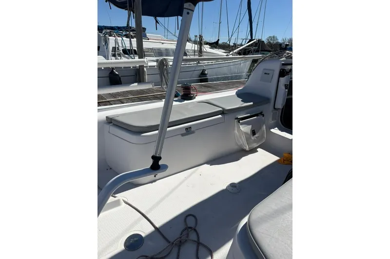 Slide: The Image of 2024 Beneteau First 27 sailboat cockpit with seating and storage, docked in marina. - 4