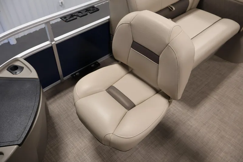 Slide: The Image of 2023 Sun Tracker Fishin' Barge 20 DLX interior seating, beige upholstery, and console detail. - 16