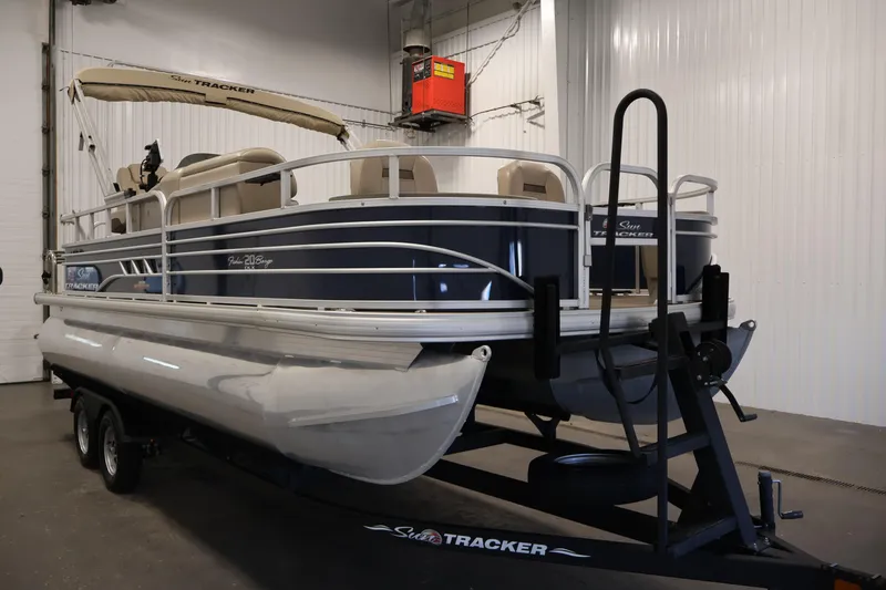 Slide: The Image of 2023 Sun Tracker Fishin' Barge 20 DLX pontoon boat on trailer in indoor storage. - 3