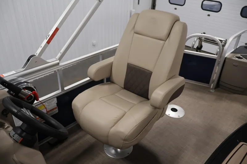 Slide: The Image of 2023 Sun Tracker Fishin' Barge 20 DLX captain's chair, beige upholstery, steering wheel visible. - 36