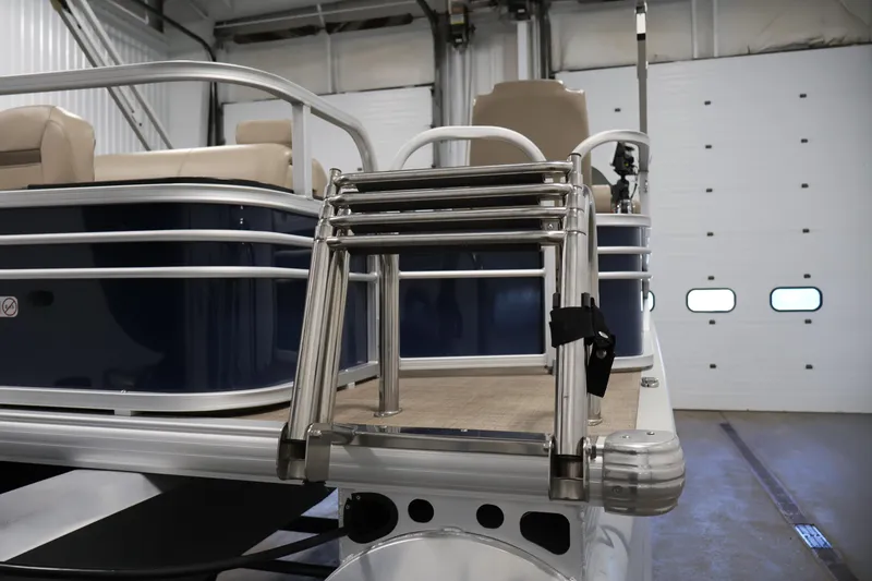 Slide: The Image of 2023 Sun Tracker Fishin' Barge 20 DLX pontoon boat with stainless steel ladder in a garage. - 49