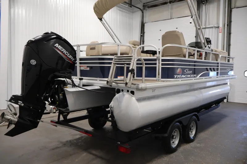 Slide: The Image of 2023 Sun Tracker Fishin' Barge 20 DLX pontoon boat with Mercury engine in a garage. - 5