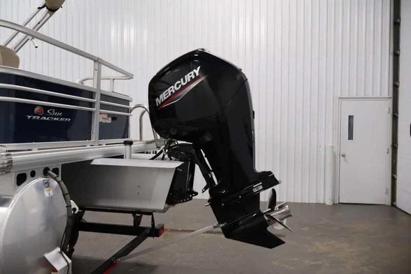 Slide: The Image of 2023 Sun Tracker Fishin' Barge 20 DLX with Mercury outboard motor in a garage. - 51