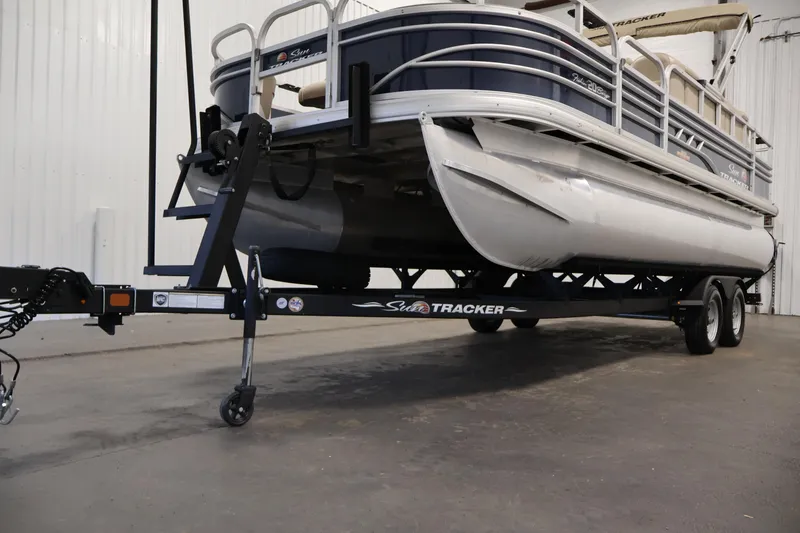 Slide: The Image of 2023 Sun Tracker Fishin' Barge 20 DLX pontoon boat on trailer in indoor setting. - 57